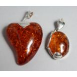 TWO SILVER AND AMBER PENDANTS.