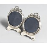 A PAIR OF SILVER CIRCULAR PHOTOGRAPH FRAMES, with pierced cresting on shaped feet. 2.5ins wide x 3.