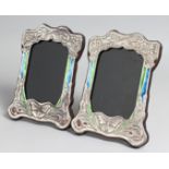 A PAIR OF SILVER AND ENAMEL PHOTOGRAPH FRAMES. 8.5ins x 6ins..