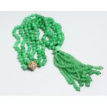 A LONG STRING OF JADE BEADS with 18ct and diamond clasp.