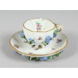 A SMALL MEISSEN FLOWER ENCRUSTED TEACUP AND SAUCER. Mark in blue, (cup A/F).