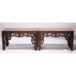 A PAIR OF CHINESE LOW RECTANGULAR TABLES each with a pierced and carved frieze, on square legs.