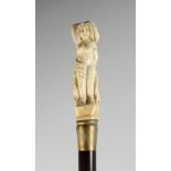 A CARVED BONE HANDLE WALKING STICK "NUDE". 36ins long.