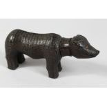 A FOLK ART LIGNUM VITAE CARVED PIG. 7.5ins long.