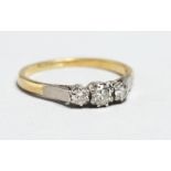 AN 18CT GOLD THREE STONE DIAMOND RING.