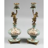 A PAIR OF BRONZE AND CHERUB CANDLESTICKS. 14ins high.