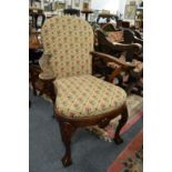 A Queen Anne style oak framed open armchair with needlework upholstered back and seat on shell