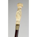 A CARVED BONE HANDLE WALKING STICK "CLENCHED FIST". 36ins long.