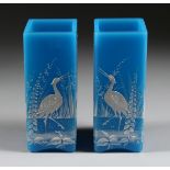 A GOOD PAIR OF BLUE MILK GLASS VASES enamelled with storks and flowers. 6.5in high.