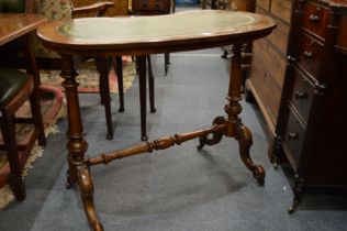 A Victorian walnut and leather inset top kidney shaped stretcher table.