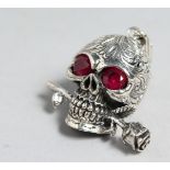 A SILVER AND RUBY EYE SKULL PENDANT.