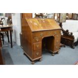 An 18th century walnut bureau with fall flap, one long drawer, three drawers to each side flanking a