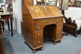 An 18th century walnut bureau with fall flap, one long drawer, three drawers to each side flanking a