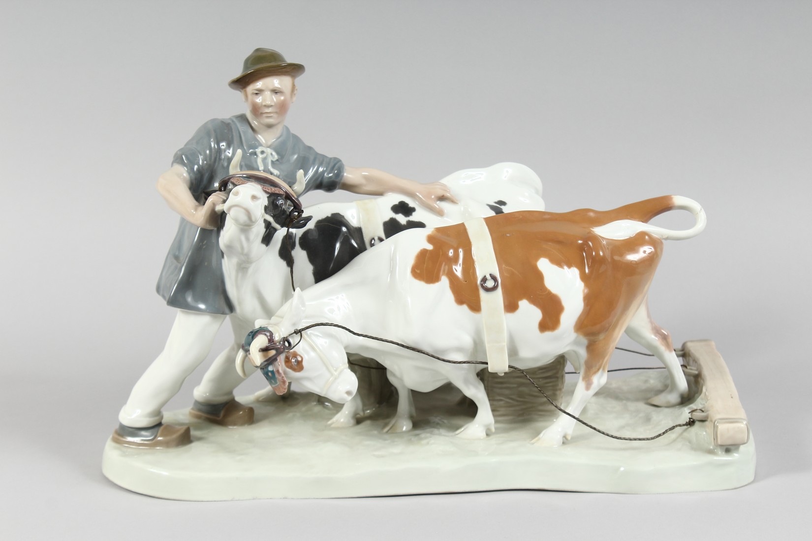 A LARGE MEISSEN GROUP, FARMER WITH TWO COWS. 16ins long, 11ins high. Cross swords mark in blue,