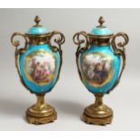 A VERY GOOD PAIR OF 19TH CENTURY SEVRES PALE BLUE, TWO HANDLED URNS AND COVERS, painted with reverse