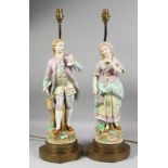 A LARGE PAIR OF CONTINENTAL FIGURES OF A YOUNG GALLANT AND A YOUNG GIRL fitted as lamps with gilt