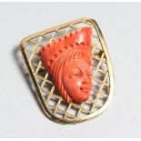 AN 18K GOLD BROOCH with a coral Egyptian head, 4cm long x 3cm wide.
