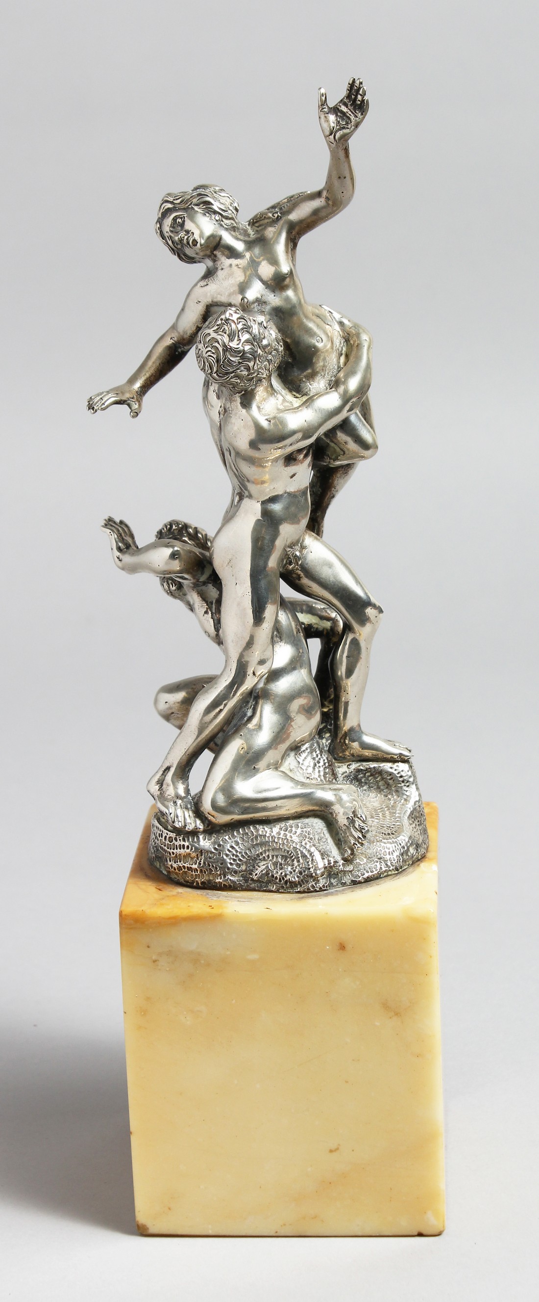 A SUPERB SILVER GROUP OF A CLASSICAL SCENE, TWO MEN AND A NUDE. 10ins high on a marble base.