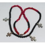 A RED AND BLACK NECKLACE with four small Roman crosses.