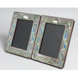 A PAIR OF SILVER AND ENAMEL PHOTOGRAPH FRAMES. 7.5ins x 5.5ins.