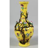 A CHINESE YELLOW GROUND FAMILLE ROSE PORCELAIN VASE decorated in relief with peach blossom, the body