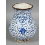 A TURKISH IZNIK BLUE AND WHITE POTTERY VASE, the body painted with swirls of foliate decoration,