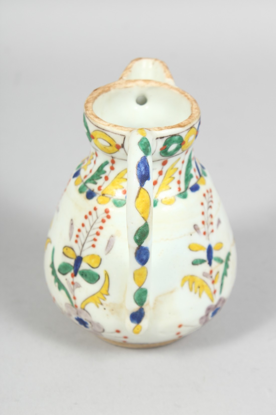 A SMALL TURKISH KUTAYHA POTTERY JUG, decorated with floral motifs, 12cm high. - Image 4 of 6