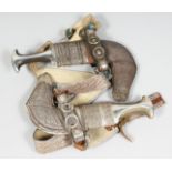 TWO FINE 19TH / EARLY 20TH CENTURY ARAB OMANI JAMBIYA DAGGERS, with bovine horn handles and original