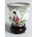 A CHINESE EGGSHELL PORCELAIN CUP AND HARDWOOD STAND, the cup painted with a female figure seated