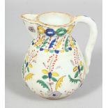 A SMALL TURKISH KUTAYHA POTTERY JUG, decorated with floral motifs, 12cm high.