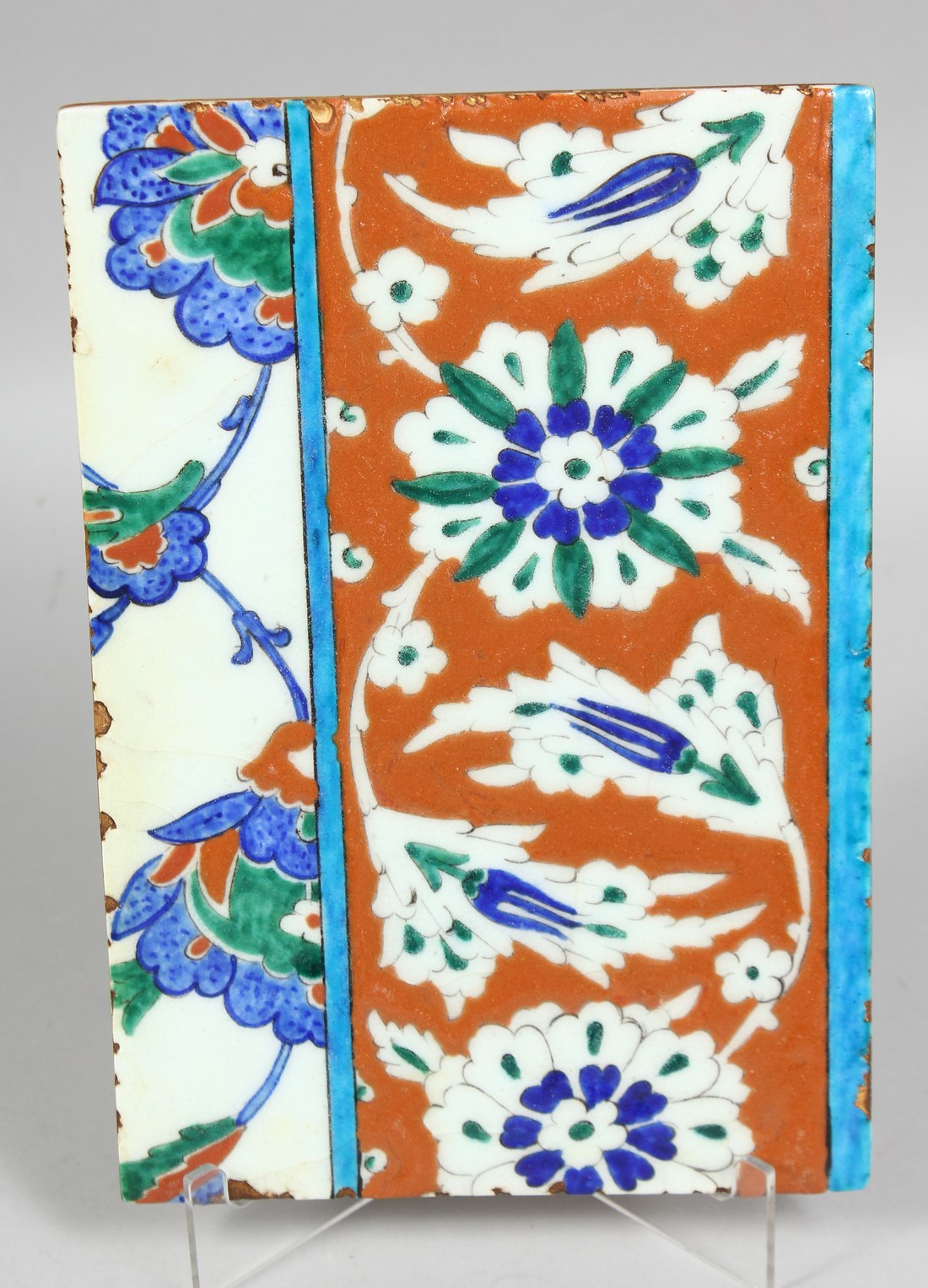 A TURKISH OTTOMAN GLAZED POTTERY TILE, painted with styilsed floral motifs, 24cm x 16.5cm.