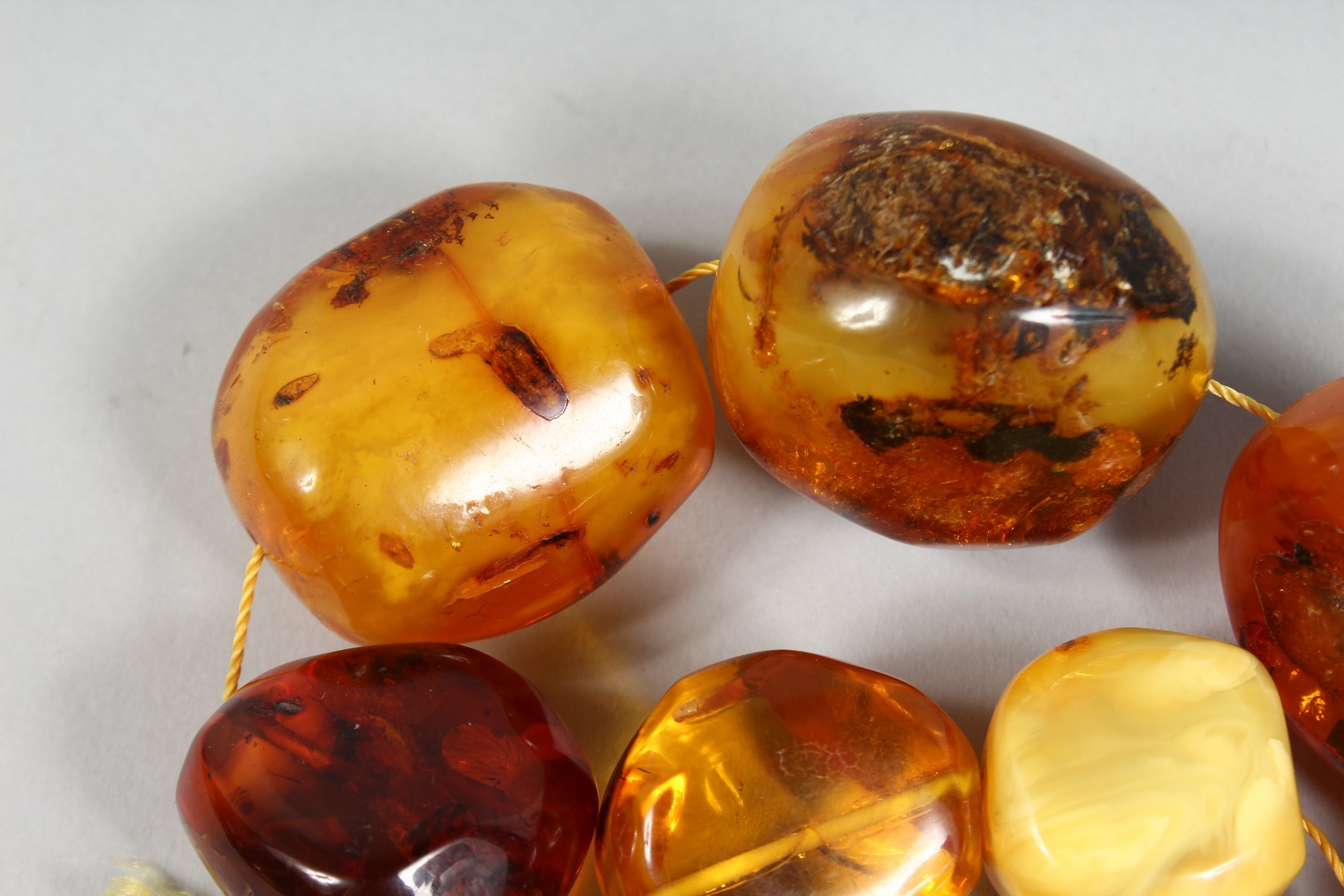 A STRING OF LARGE AMBER TYPE NATURALISTIC BEADS, various shapes and sixes, comprising 15 beads. - Image 4 of 4
