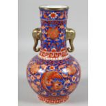 A CHINESE BLUE GROUND AND CORAL RED TWIN-HANDLED VASE painted with birds and large flower heads, the