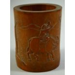 A CHINESE CARVED BAMBOO BRUSH POT, the side carved with a figure on an oxen, 15cm high.