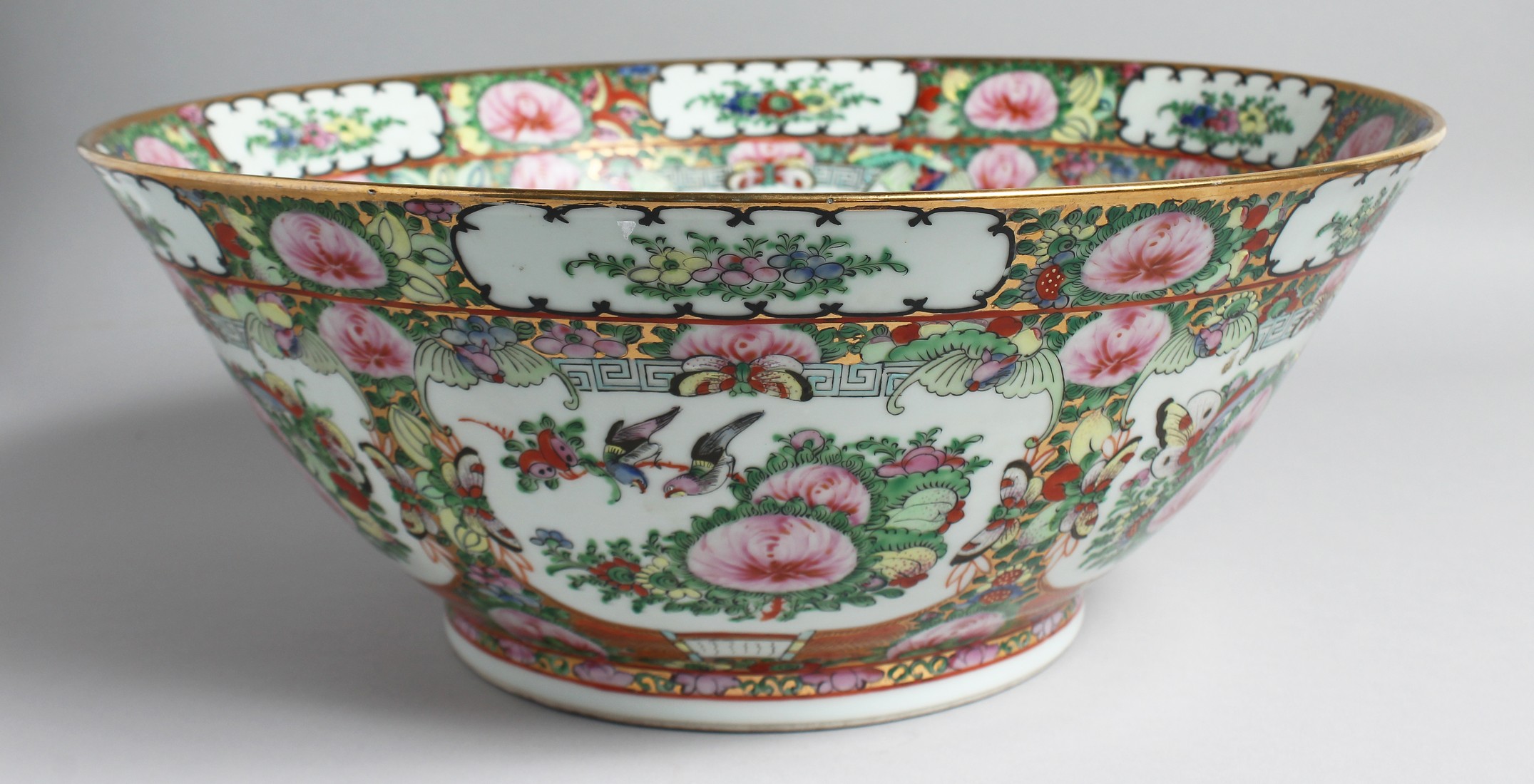 A LARGE CHINESE CANTON PORCELAIN PUNCH BOWL, painted with multiple panels of floral motifs and