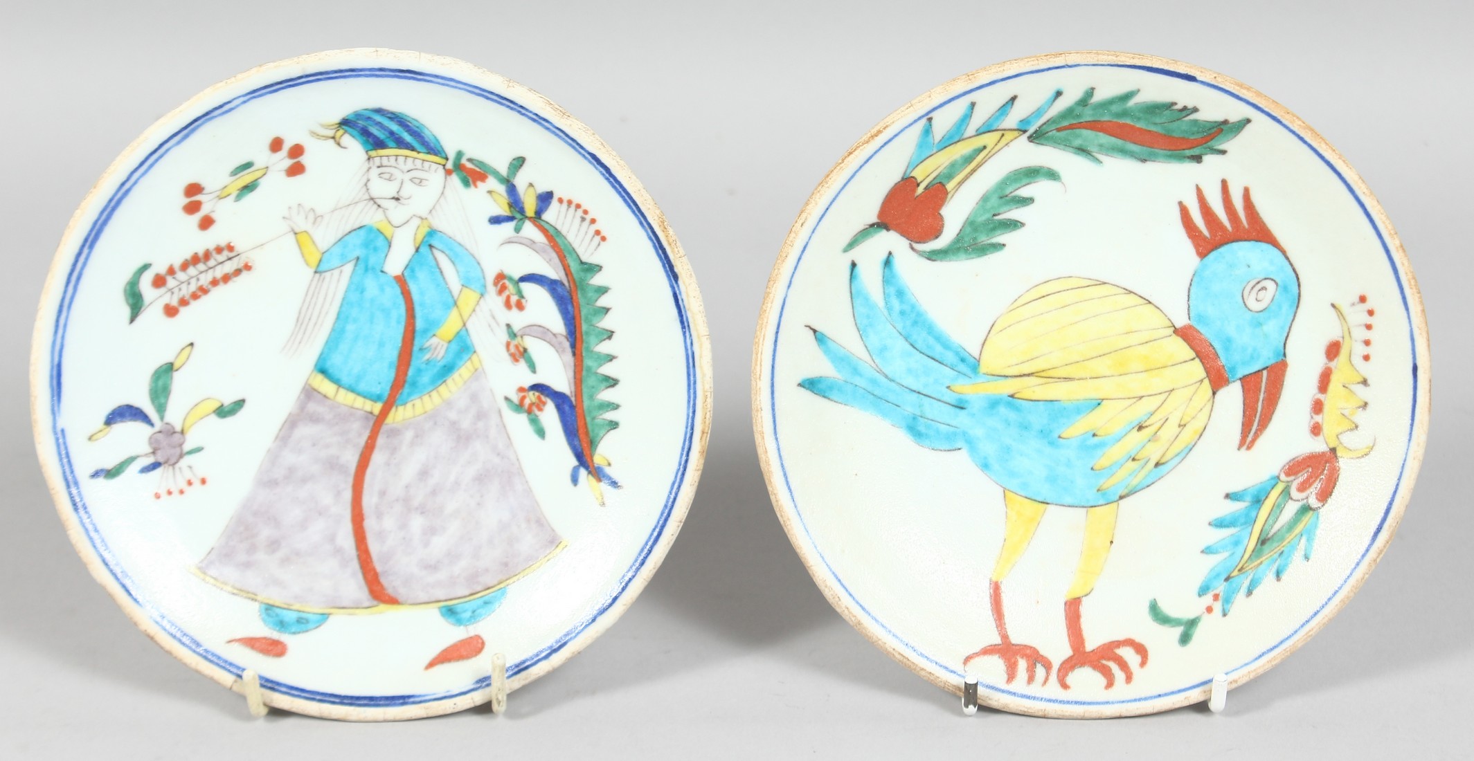 TWO TURKISH KUTAHYA GLAZED POTTERY DISHES, one painted with a figure, the other with a bird, each