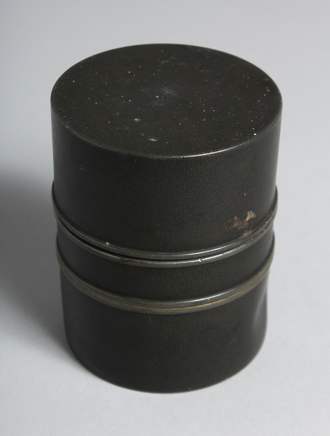 A CHINESE CYLINDRICAL METAL TEA CADDY, the base with impressed mark. 10cm high