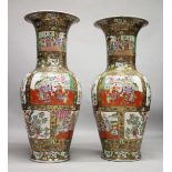 A VERY LARGE PAIR OF CHINESE CANTON FAMILLE ROSE PORCELAIN FLOOR STANDING VASES, decorated with