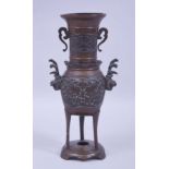 A JAPANESE MEIJI PERIOD BRONZE TRIPOD VASE, decorated with phoenix panels and handles, 25.5cm high.