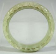 A CHINESE CARVED AND PIERCED JADE BRACELET, 8cm diameter.