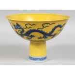 A CHINESE IMPERIAL YELLOW GROUND BLUE AND WHITE PORCELAIN STEM CUP, decorated with dragons and