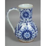A TURKISH KUTAHYA BLUE AND WHITE GLAZED WATER JUG, painted with stylised flower heads, 22cm high.