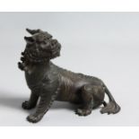 A BRONZE FIGURE OF A LION DOG, 15cm long.