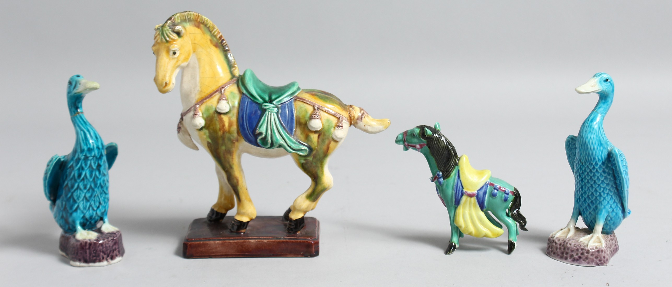 A COLLECTION OF FOUR CHINESE GLAZED POTTERY FIGURES OF ANIMALS, including a sancai horse, 14cm long;