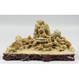 A GOOD CHINESE SOAPSTONE CARVING of a landscape scene with buildings amongst mountains, mounted to a