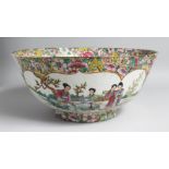 A LARGE CHINESE CANTON PORCELAIN PUNCH BOWL, the interior painted with female figures in a garden,