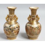 A PAIR OF SMALL JAPANESE SATSUMA PORCELAIN TWIN HANDLE VASES, painted with figures and gilt