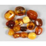 A STRING OF LARGE AMBER TYPE NATURALISTIC BEADS, various shapes and sixes, comprising 15 beads.