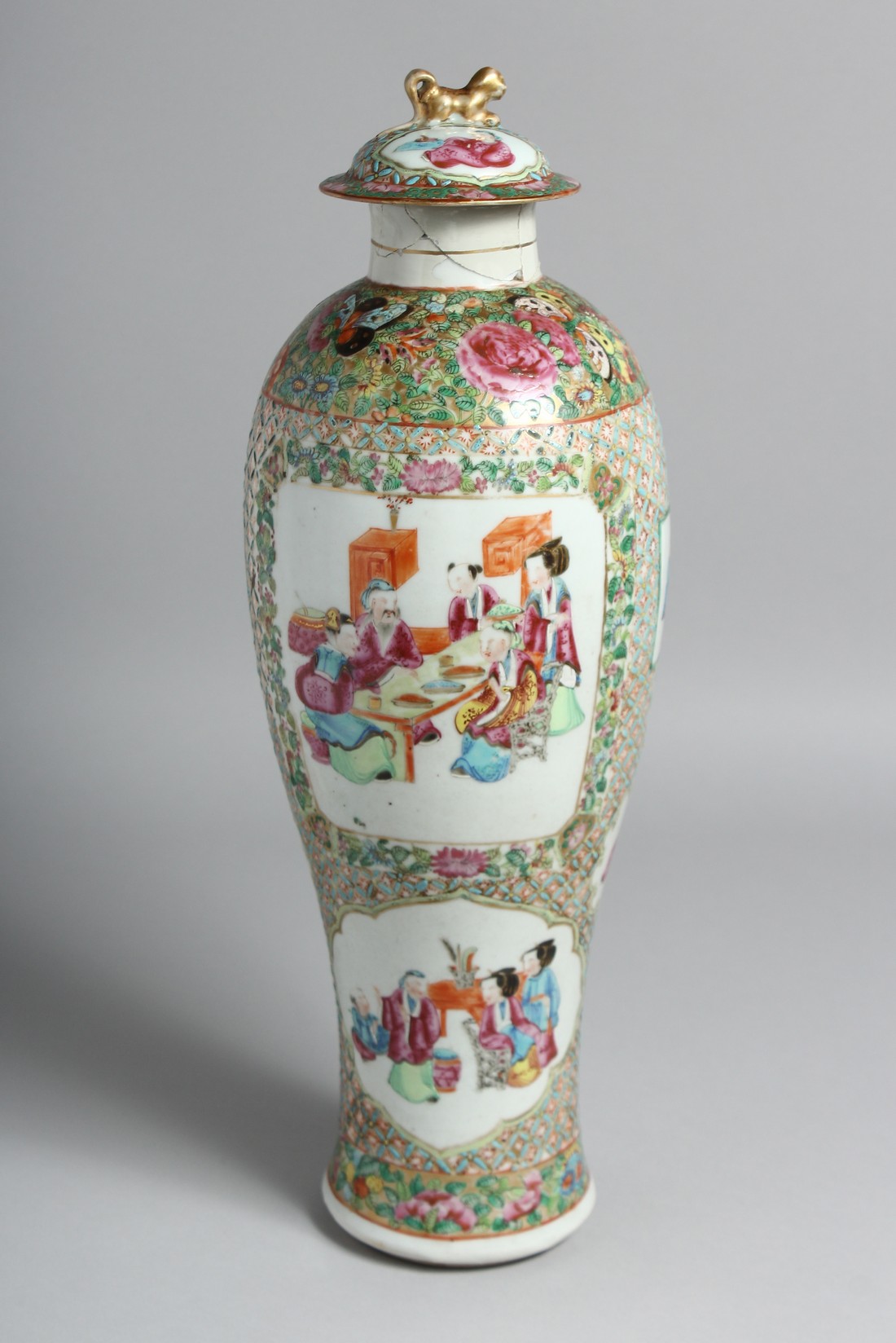A TALL CHINESE CANTON PORCELAIN VASE AND COVER painted with panels of seated figures and further