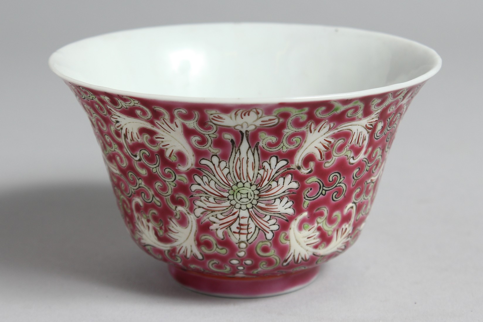 A CHINESE PINK GROUND PORCELAIN ENAMELLED BOWL with stylised floral motifs and vine, the base with